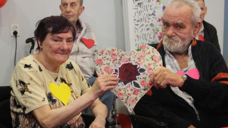 na zdjęciu mężczyzna i kobieta trzymają papierową walentynkę w kształcie serca